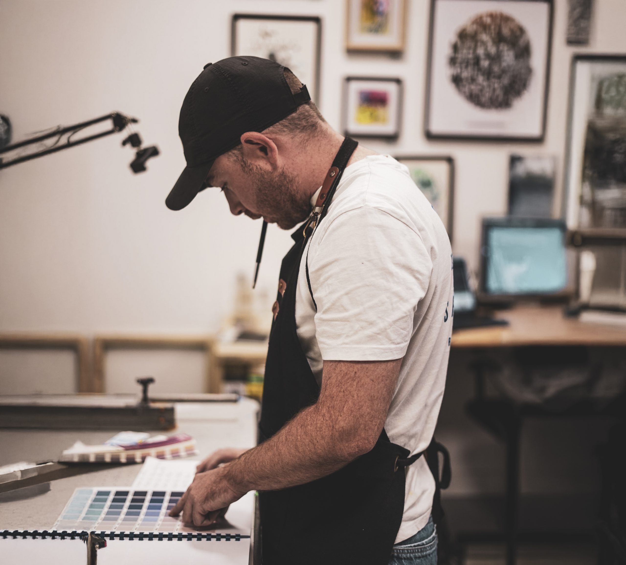 Un imprimeur consulte un nuancier de couleurs dans l’atelier
